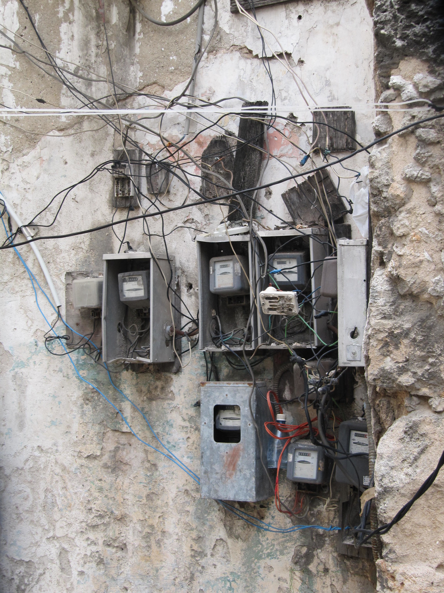 Laten we niet vergeten dat internet en elektriciteit niet overal en altijd beschikbaar zijn. “Dodgy electrics!” Open meters en kabels in een achterafstraatje in Havana door Andy D'Agornen, gelicentieerd onder CC BY-NC-ND 2.0.
